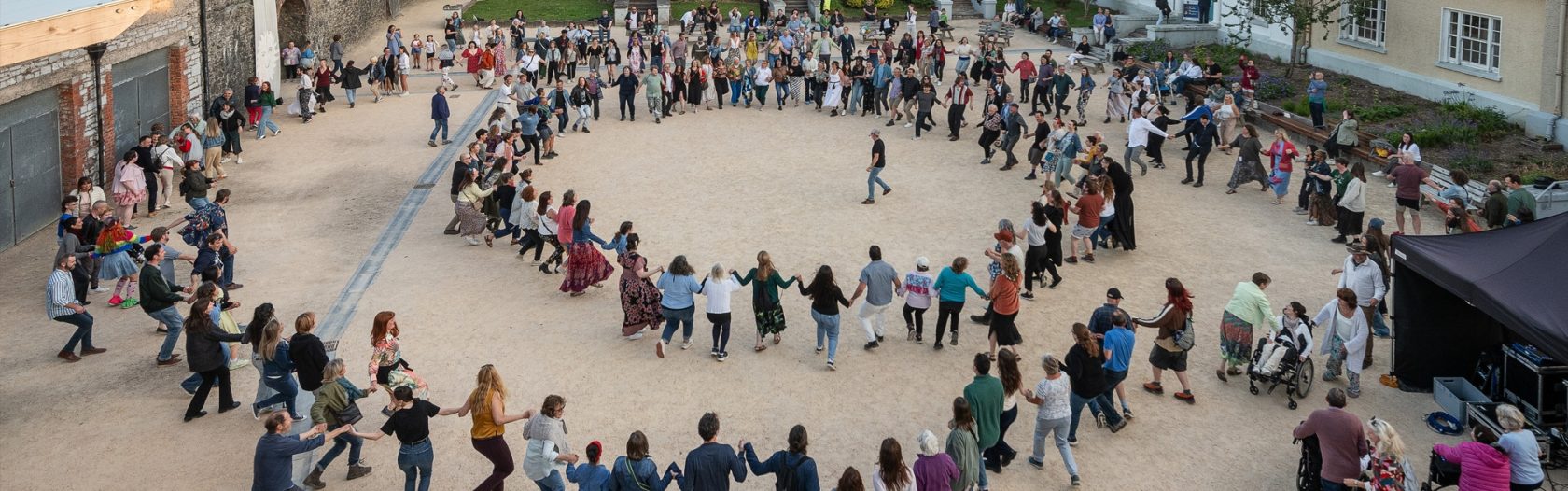 Solstice Ceili, two large cricles of people holding hands and dancing outdoors